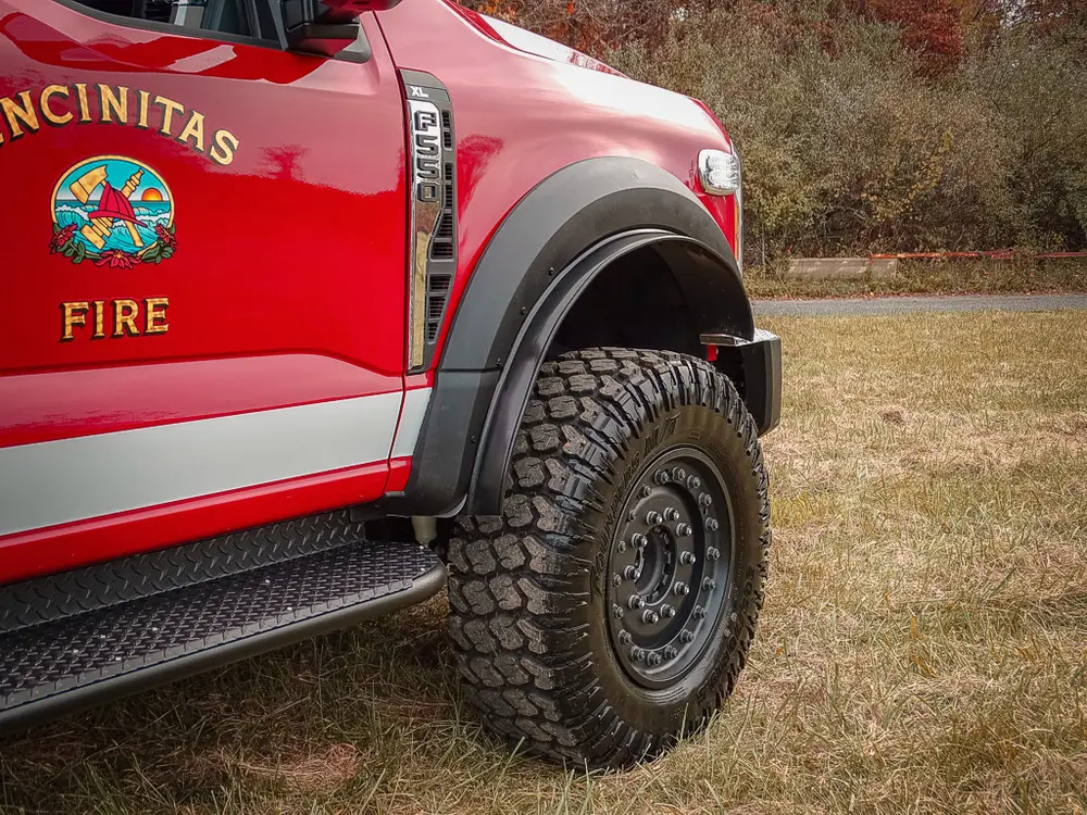 Driver-side front wheel and fender profile on grass.