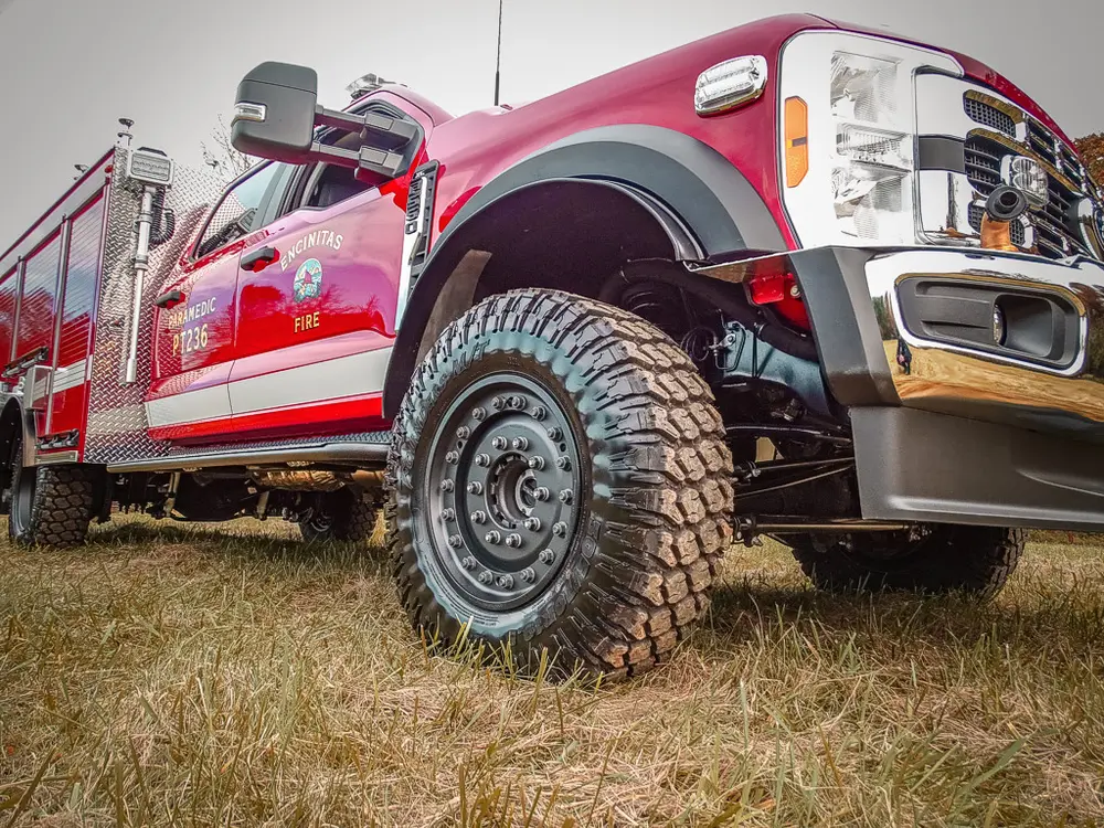 Low front three-quarter view emphasizing off-road tire and bumper.