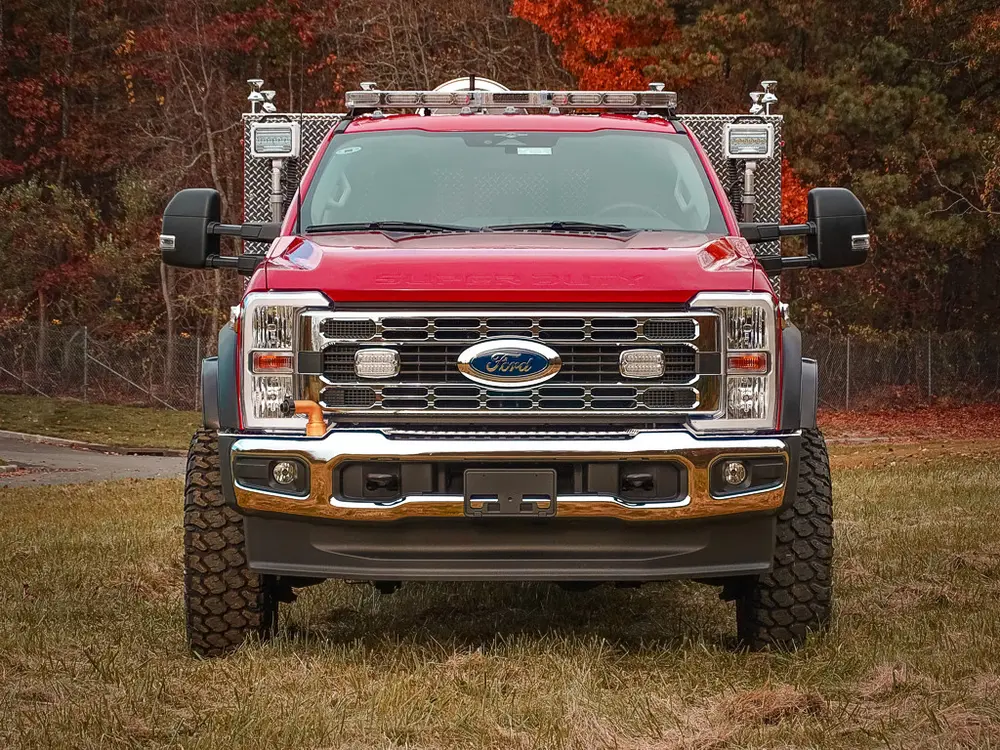 Head-on front view with grille guard and roof lights.