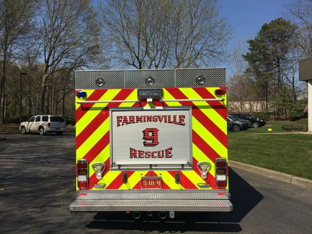 Exterior view of small fire truck showing cab, body compartments, and wheel/tire area.