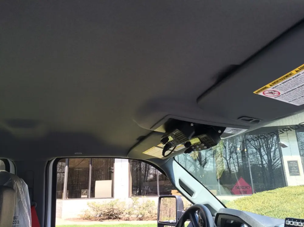 Exterior view of small fire truck showing cab, body compartments, and wheel/tire area.