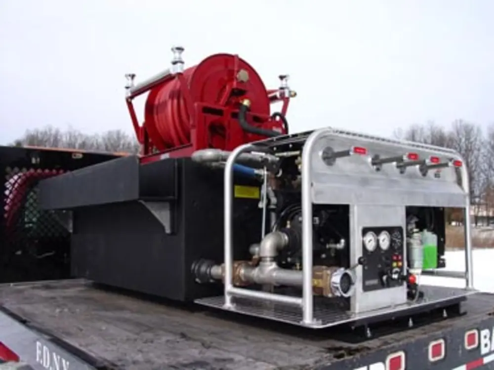 Exterior view of small fire truck showing cab, body compartments, and wheel/tire area.