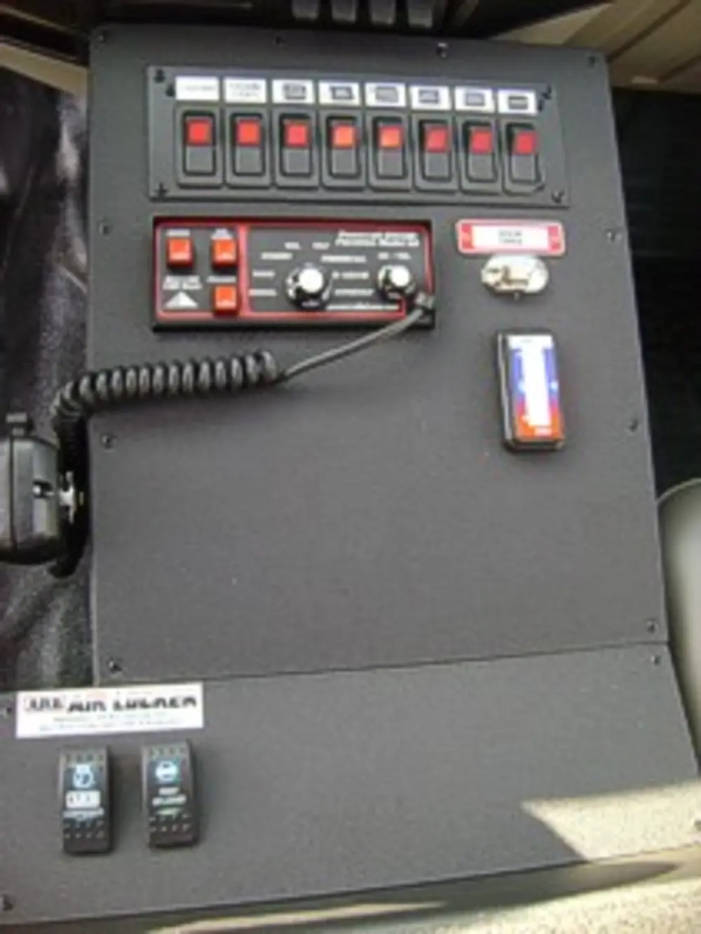 Exterior view of small fire truck showing cab, body compartments, and wheel/tire area.