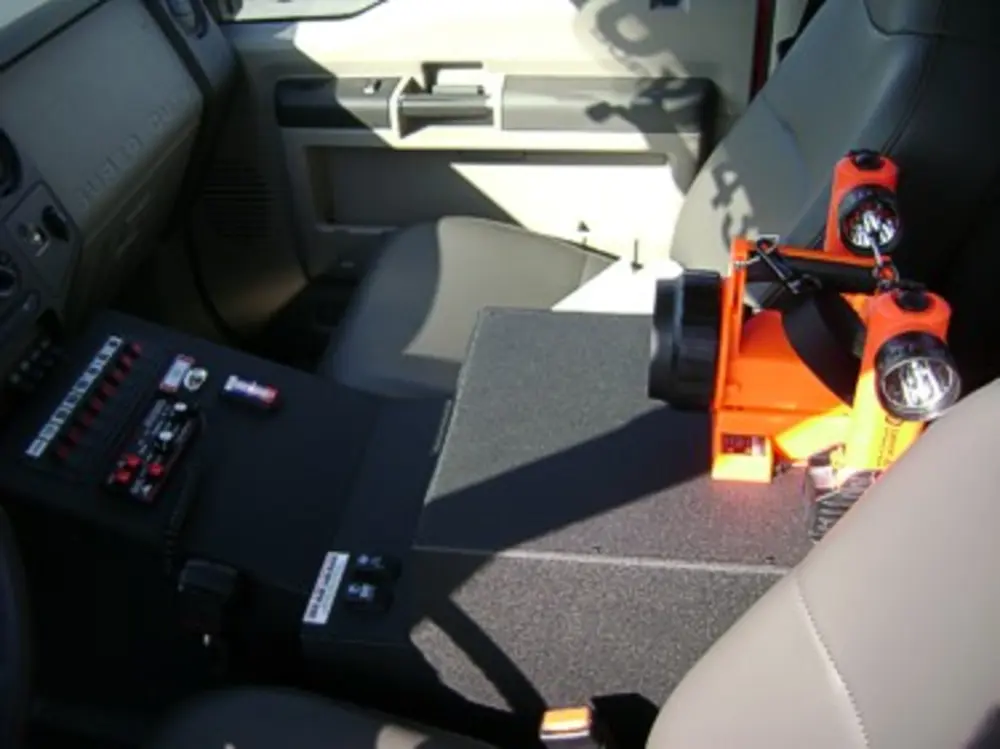 Exterior view of small fire truck showing cab, body compartments, and wheel/tire area.