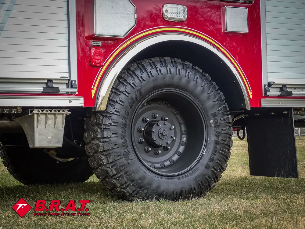 Rear wheel close-up showing aggressive tread and mudflap.