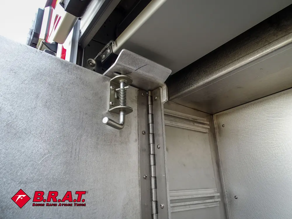 Compartment interior corner close-up with hinge and smooth metal walls.