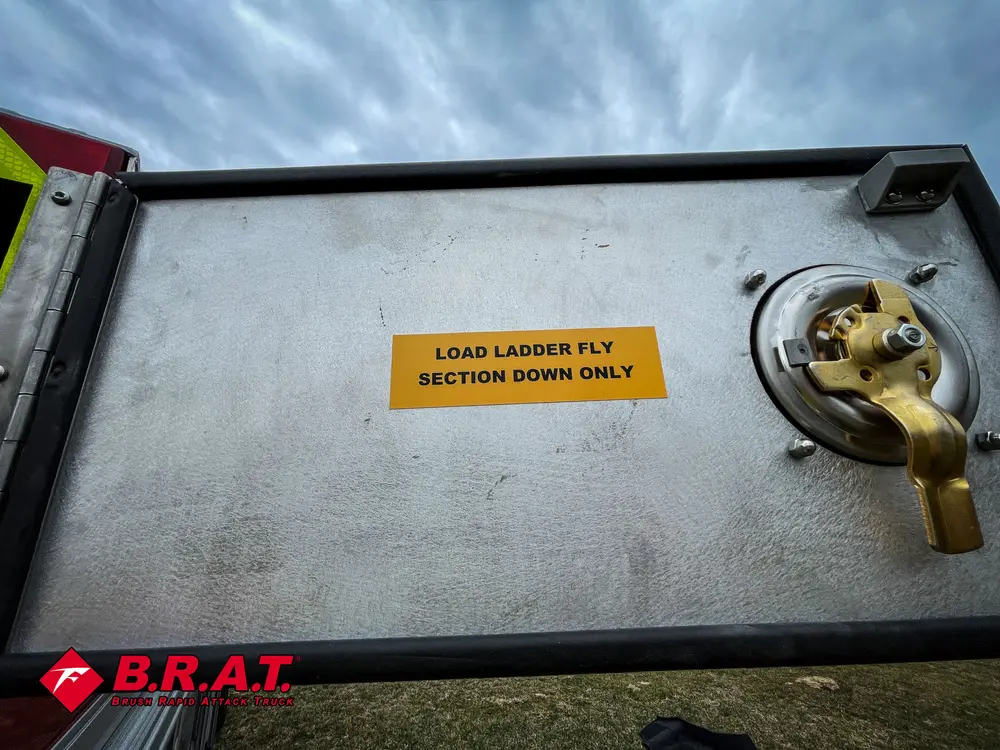 Rear-side compartment close-up with brass valve and warning label.