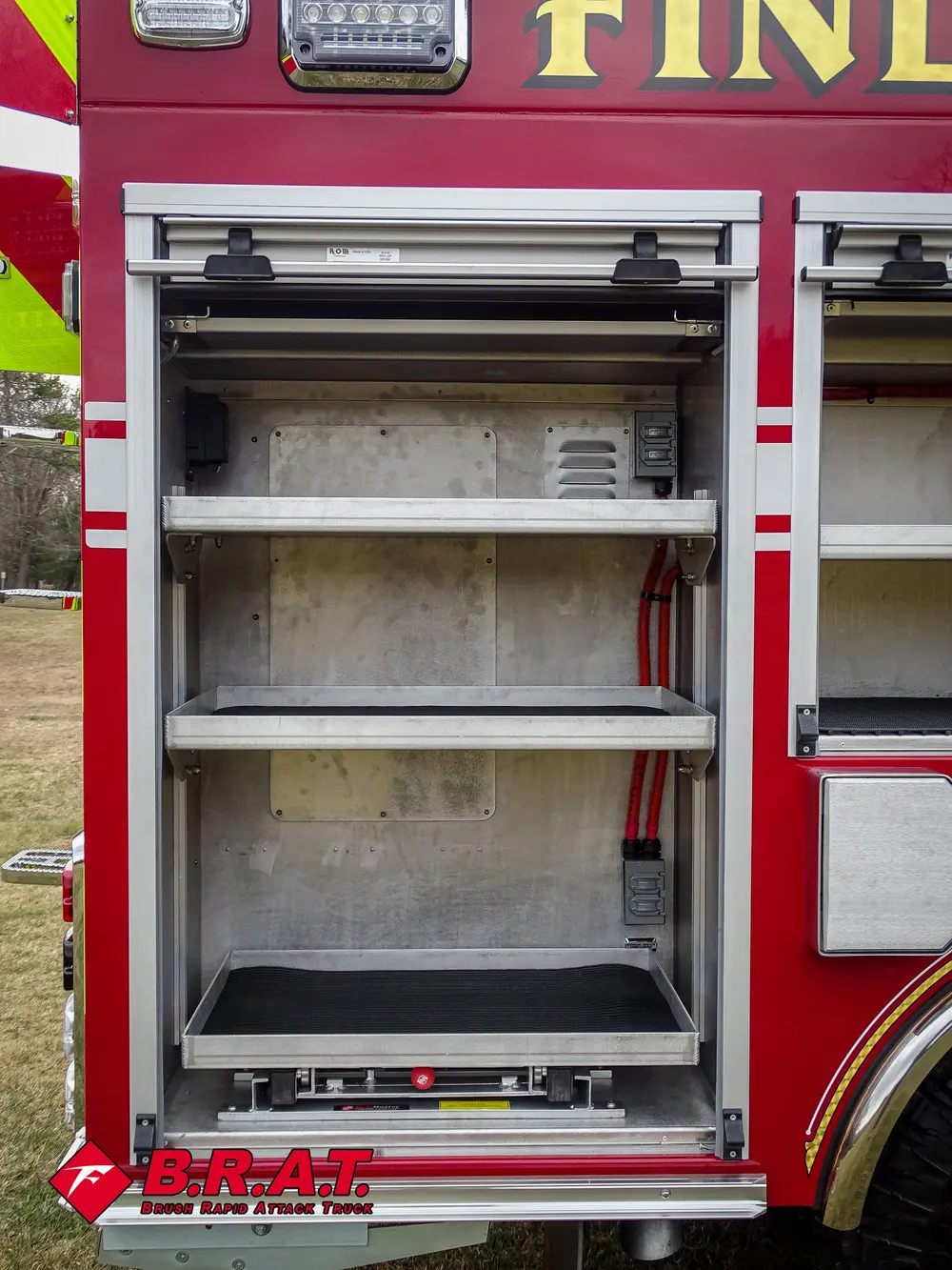Open side shelf compartment with red straps hanging at right.