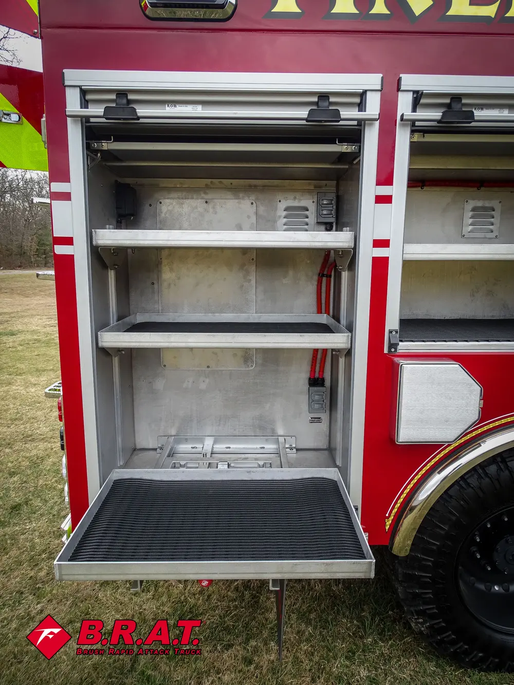 Open side compartment with two metal shelves and rubber-lined floor.