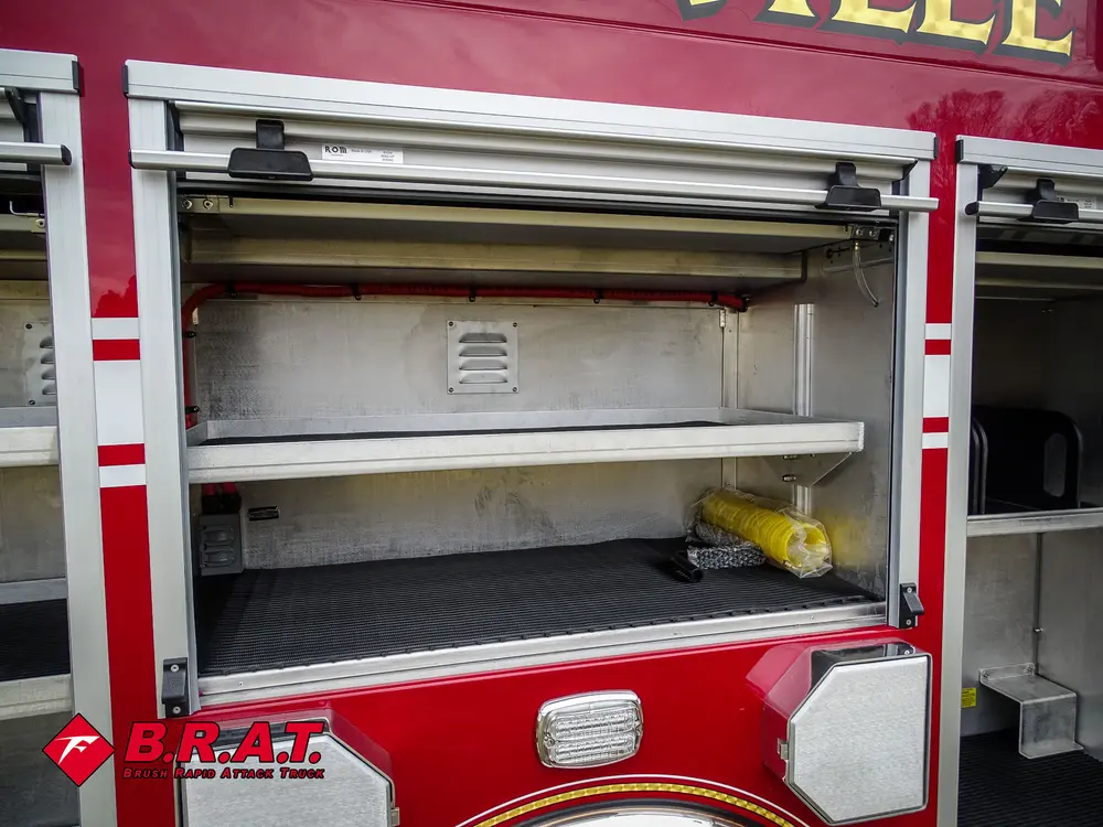 Wide side compartment with roll-up door and two long shelves.