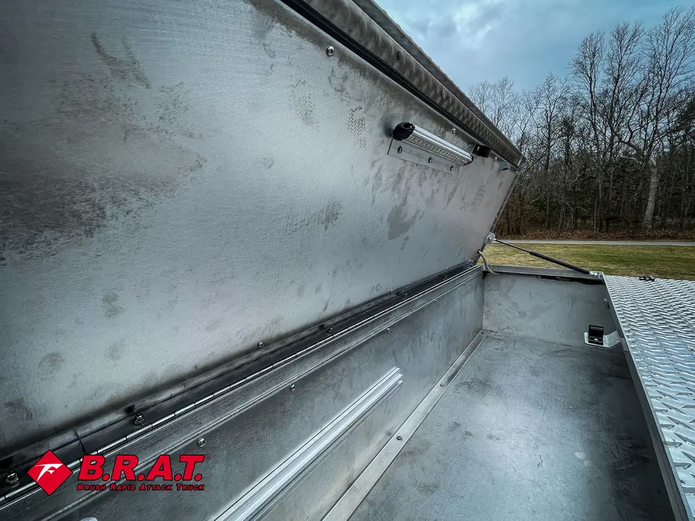 Long empty aluminum top compartment with open lid.