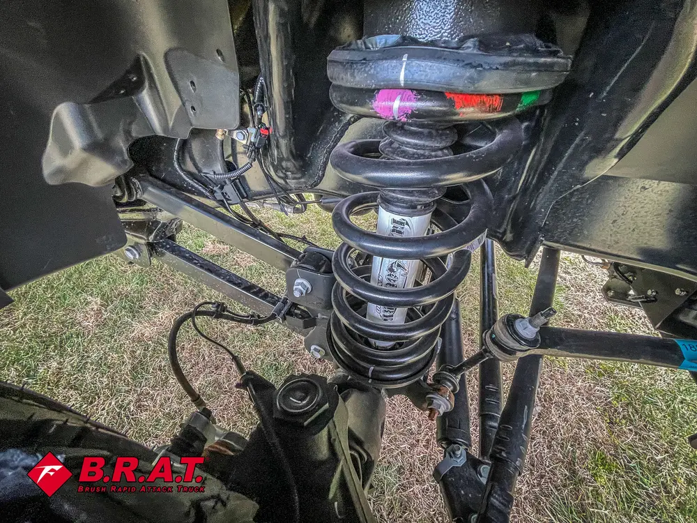 Close-up of rear suspension spring and wiring beneath the chassis.