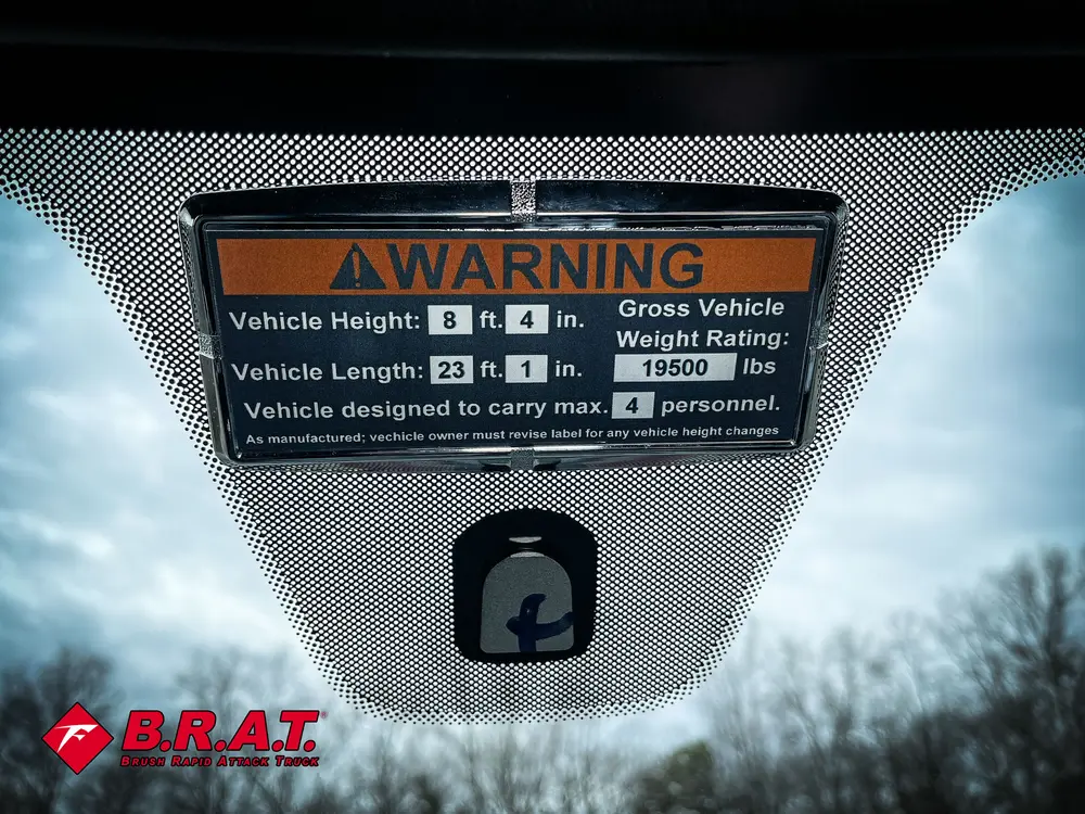 Windshield warning placard showing vehicle dimensions and weight.
