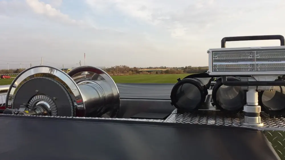 Exterior view of small fire truck showing cab, body compartments, and wheel/tire area.