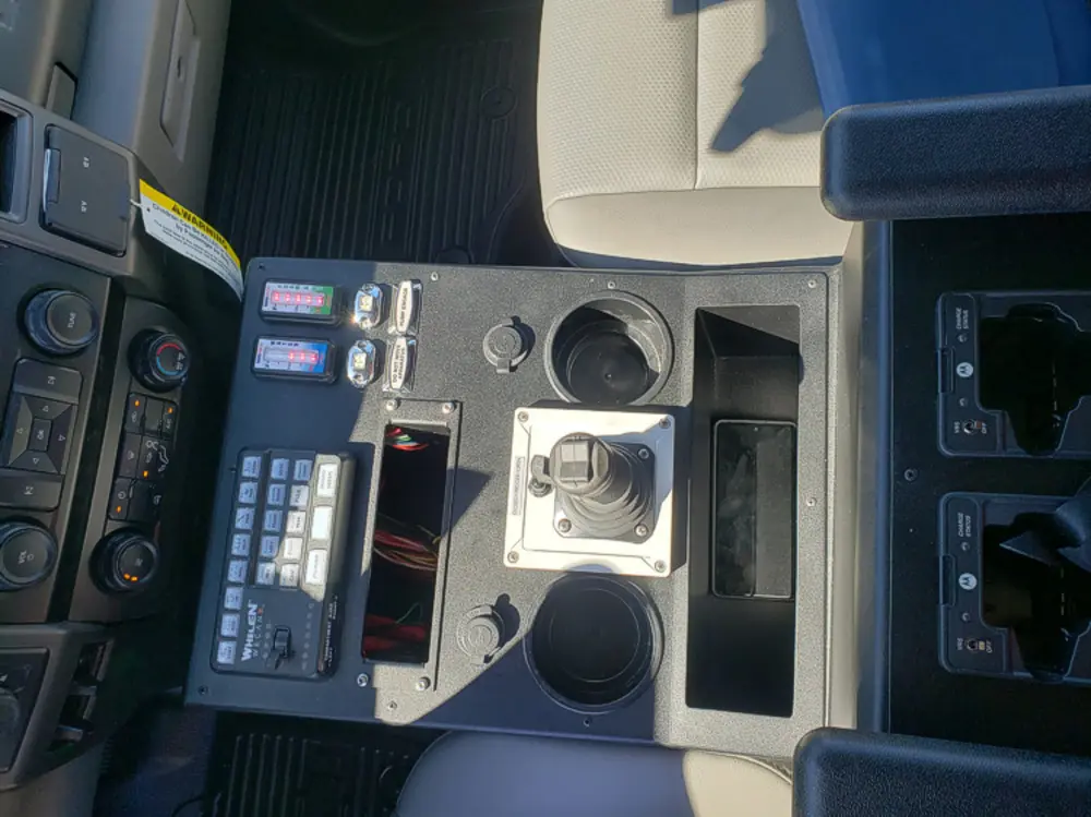 Exterior view of small fire truck showing cab, body compartments, and wheel/tire area.