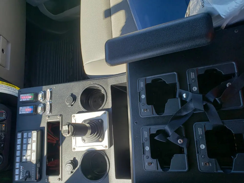 Exterior view of small fire truck showing cab, body compartments, and wheel/tire area.