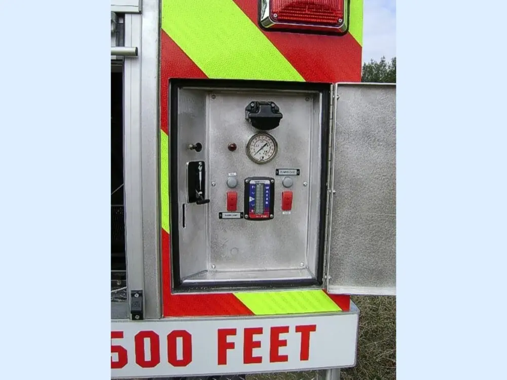Exterior view of small fire truck showing cab, body compartments, and wheel/tire area.
