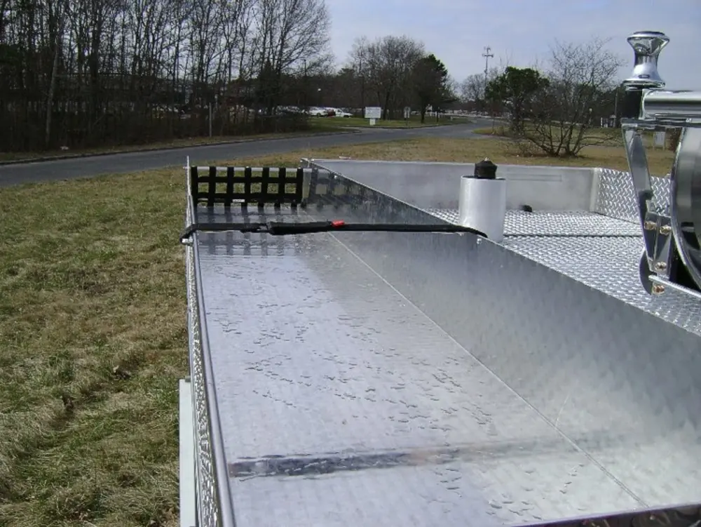 Exterior view of small fire truck showing cab, body compartments, and wheel/tire area.