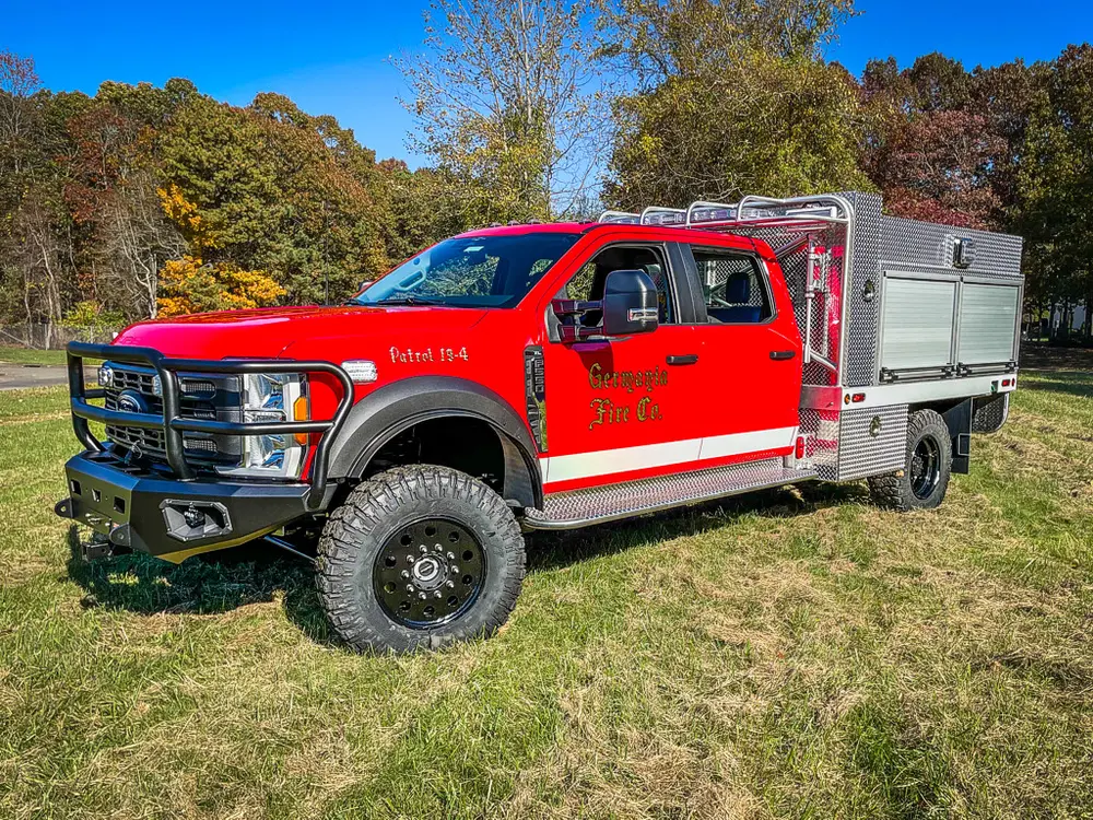 Front-left side view showing cab and silver utility compartments.