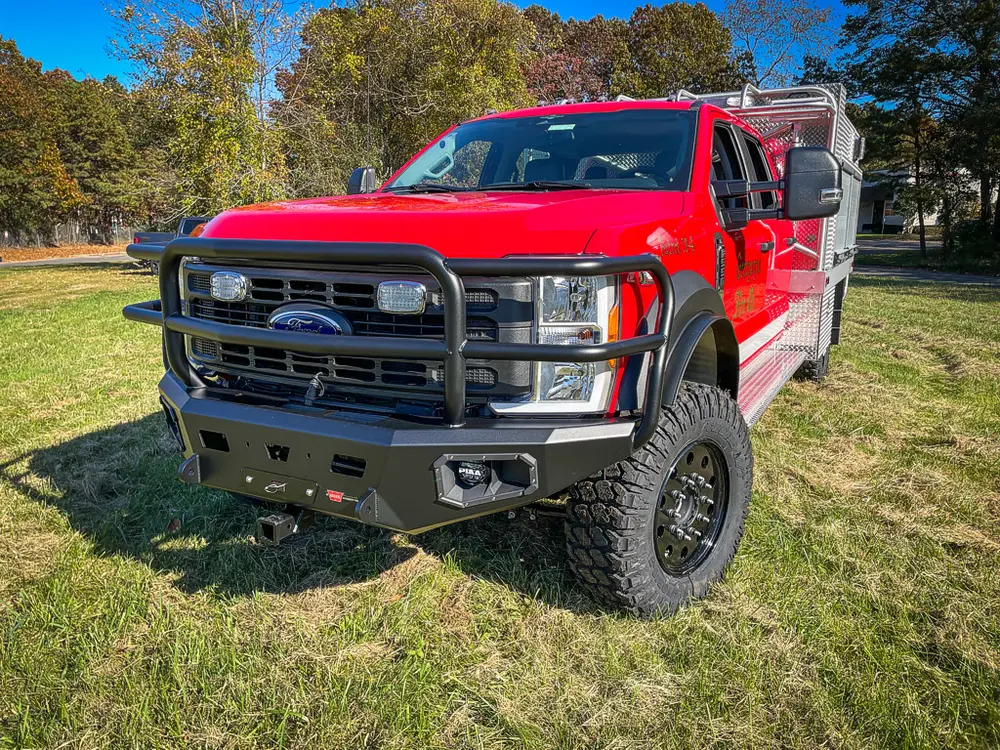 Low front-left angle emphasizing grille guard and lifted stance.