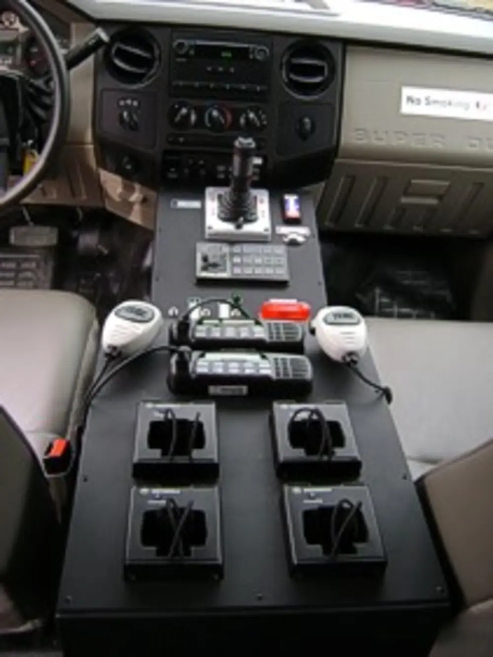 Exterior view of small fire truck showing cab, body compartments, and wheel/tire area.