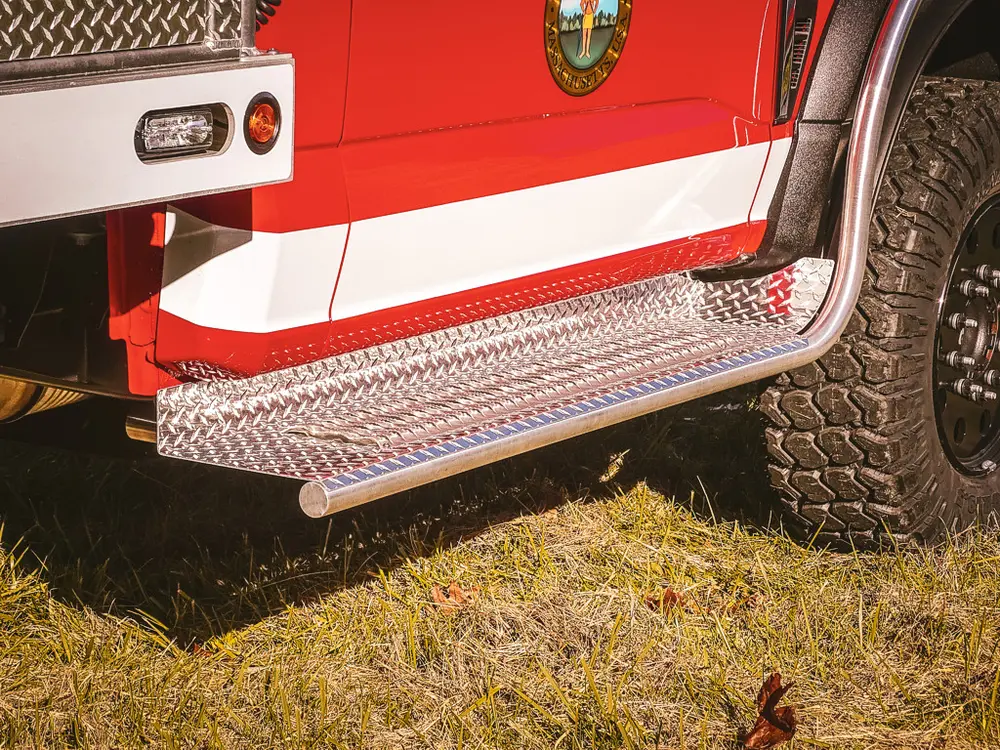 Cab side-step close-up with textured step and lower marker light.