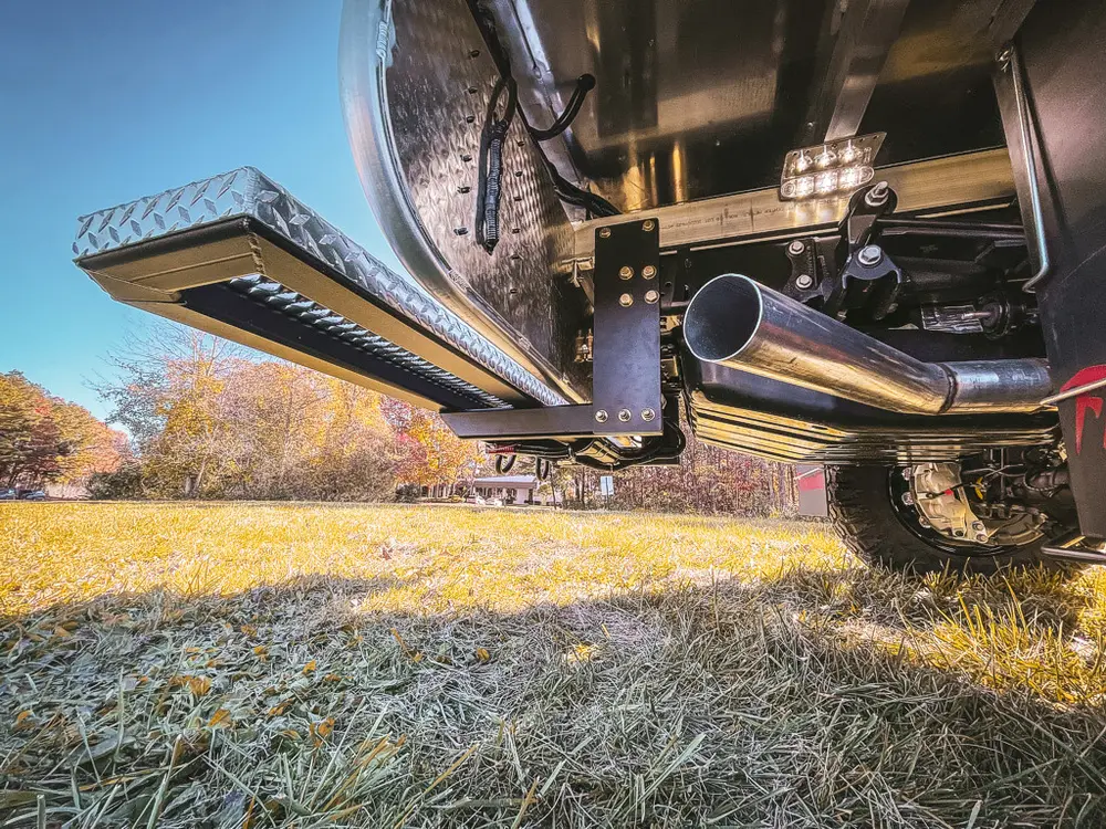 Rear underside close-up with fold-down step, exhaust, and underbody components.
