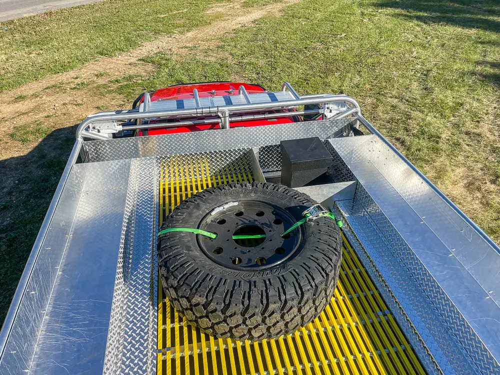 Top deck view with spare tire strapped over yellow grated walkway.