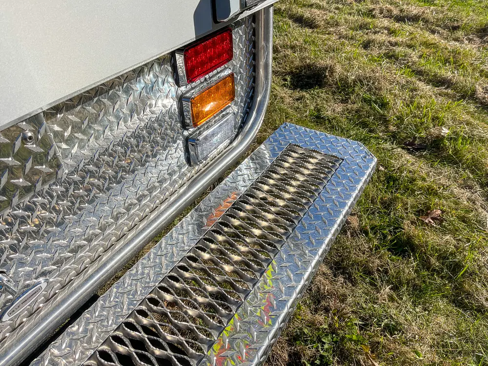 Rear corner close-up with taillight and fold-down step platform.