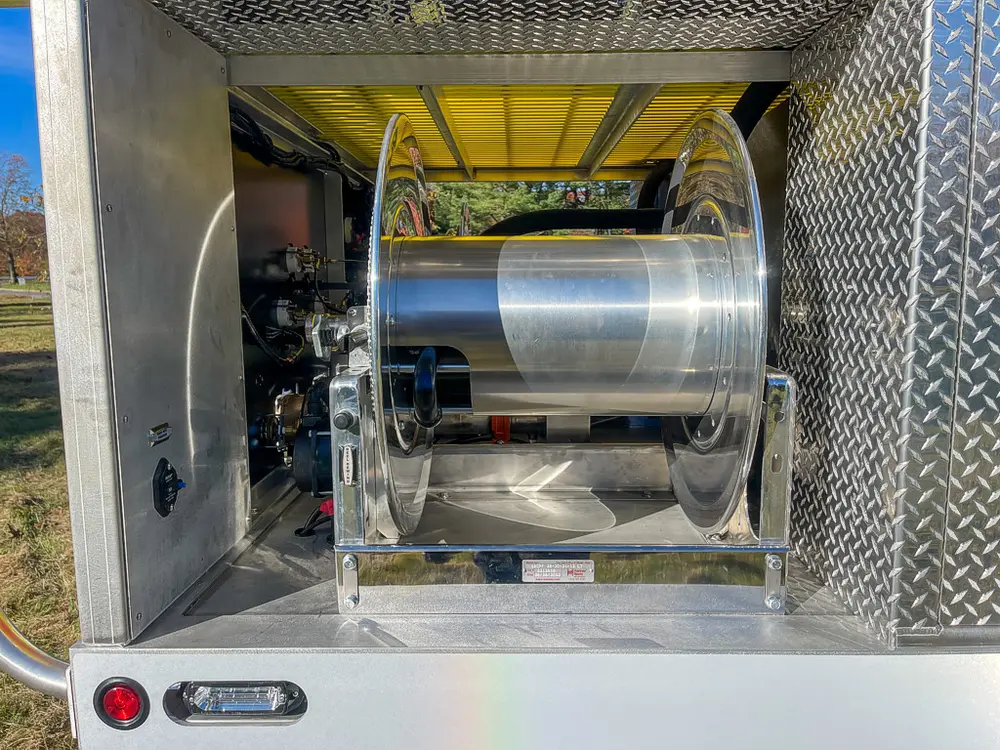 Rear compartment with hose reel assembly mounted inside.