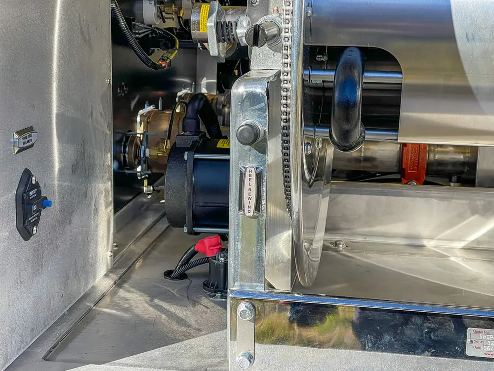 Hose reel mechanism and metal tubing close-up in rear bay.