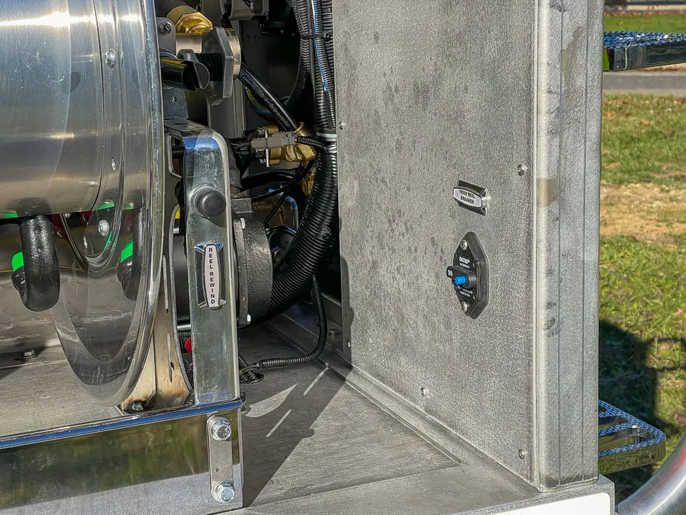 Hose reel side close-up with drive mechanism and fittings.