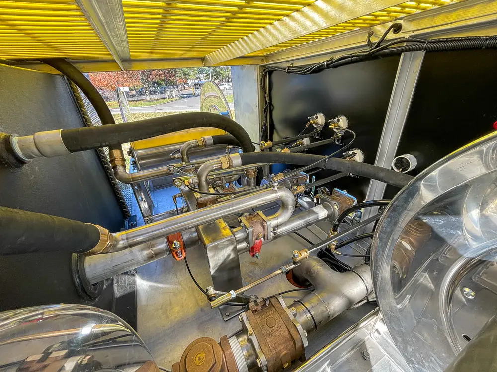 Pump plumbing close-up with metal pipes and valve hardware.
