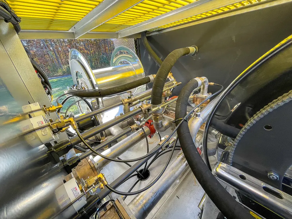 Dense piping and valves close-up inside pump compartment.