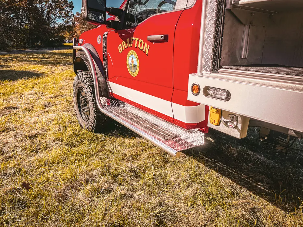 Side step and lower cab trim close-up near rear wheel.