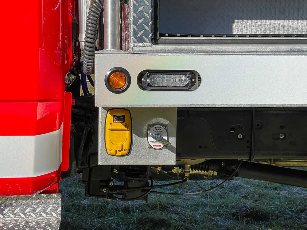 Rear corner underbody close-up with marker light and connector panel.