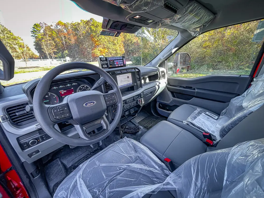 Front cabin interior view with steering wheel and center console.