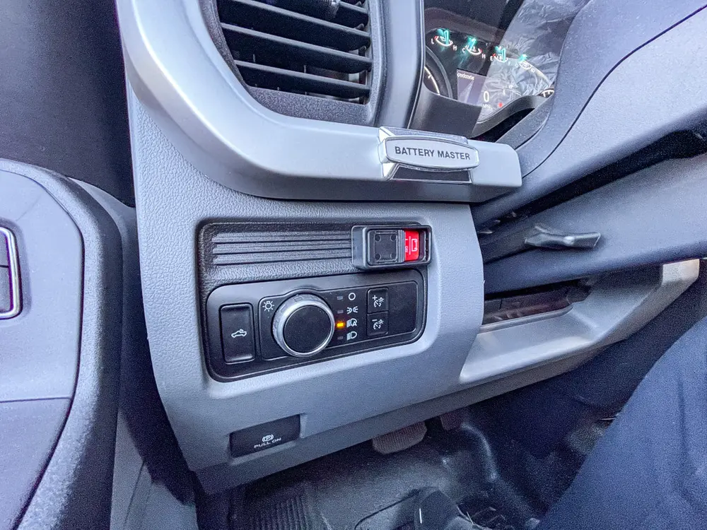 Dashboard side controls close-up with rotary selector and buttons.