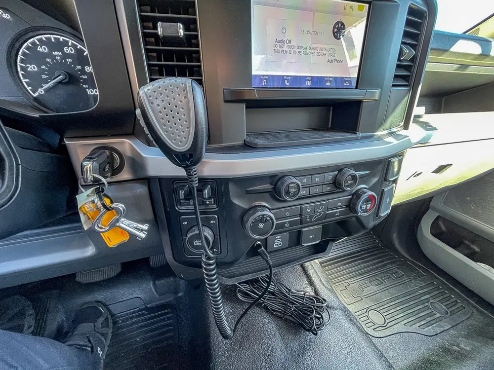 Center dashboard close-up with radio display, climate controls, and microphone.