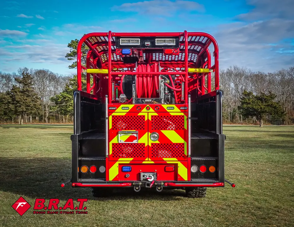 Exterior view of small fire truck showing cab, body compartments, and wheel/tire area.