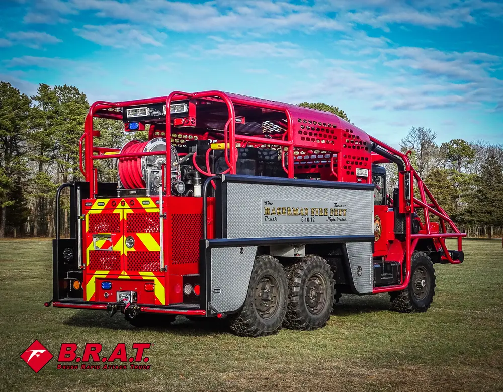 Exterior view of small fire truck showing cab, body compartments, and wheel/tire area.