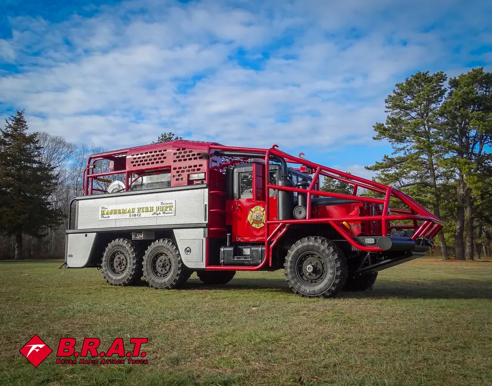Exterior view of small fire truck showing cab, body compartments, and wheel/tire area.