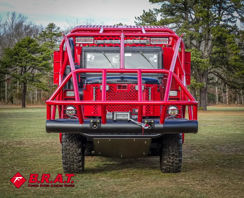 Exterior view of small fire truck showing cab, body compartments, and wheel/tire area.