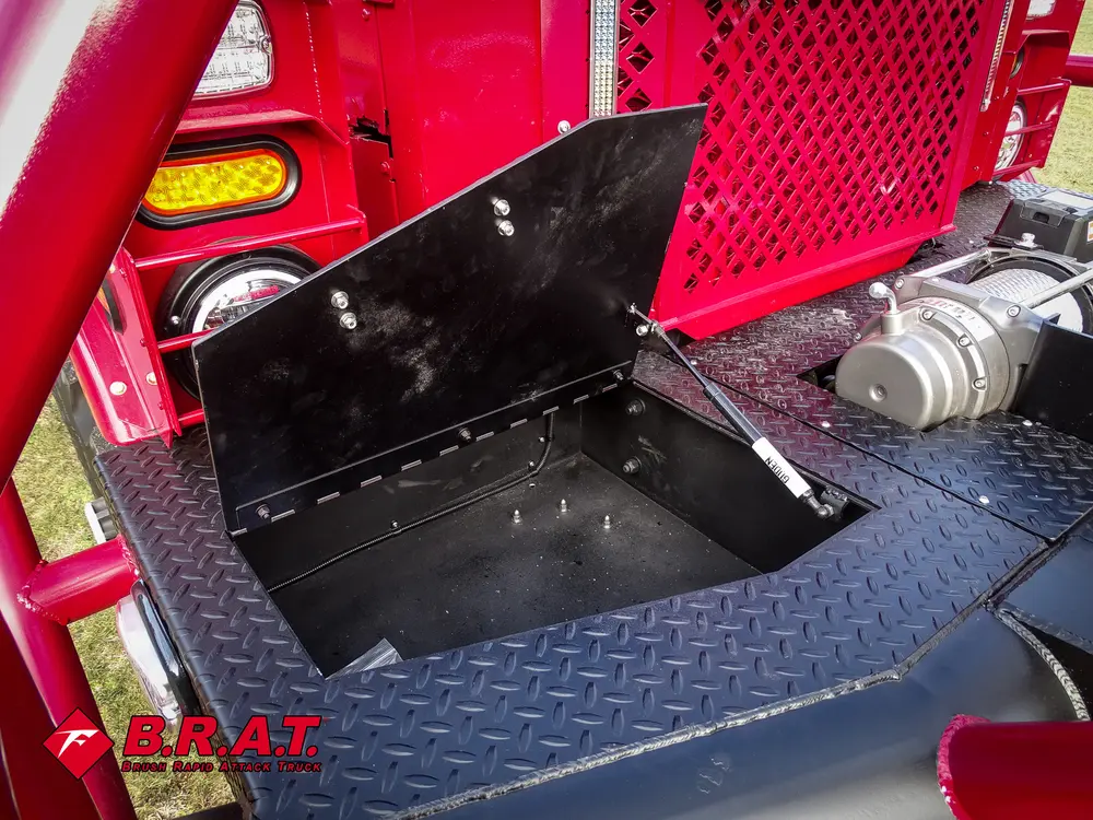 Exterior view of small fire truck showing cab, body compartments, and wheel/tire area.