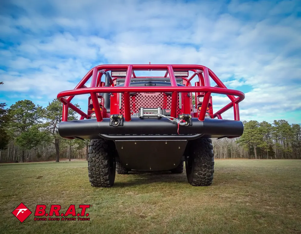 Exterior view of small fire truck showing cab, body compartments, and wheel/tire area.