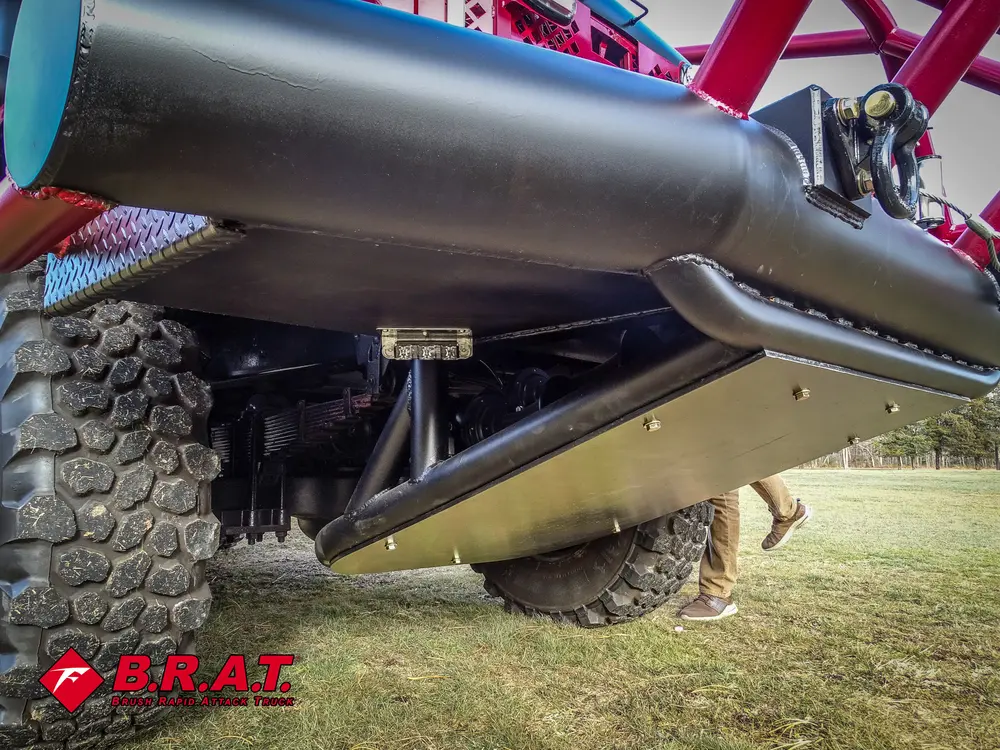 Exterior view of small fire truck showing cab, body compartments, and wheel/tire area.