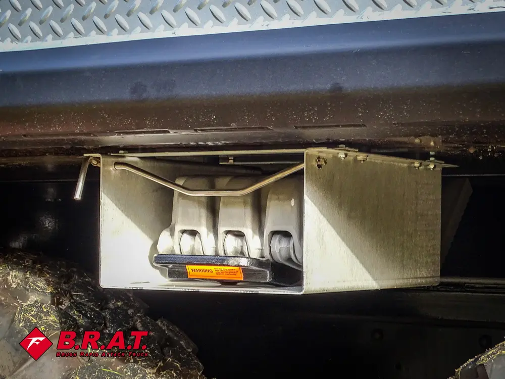 Exterior view of small fire truck showing cab, body compartments, and wheel/tire area.