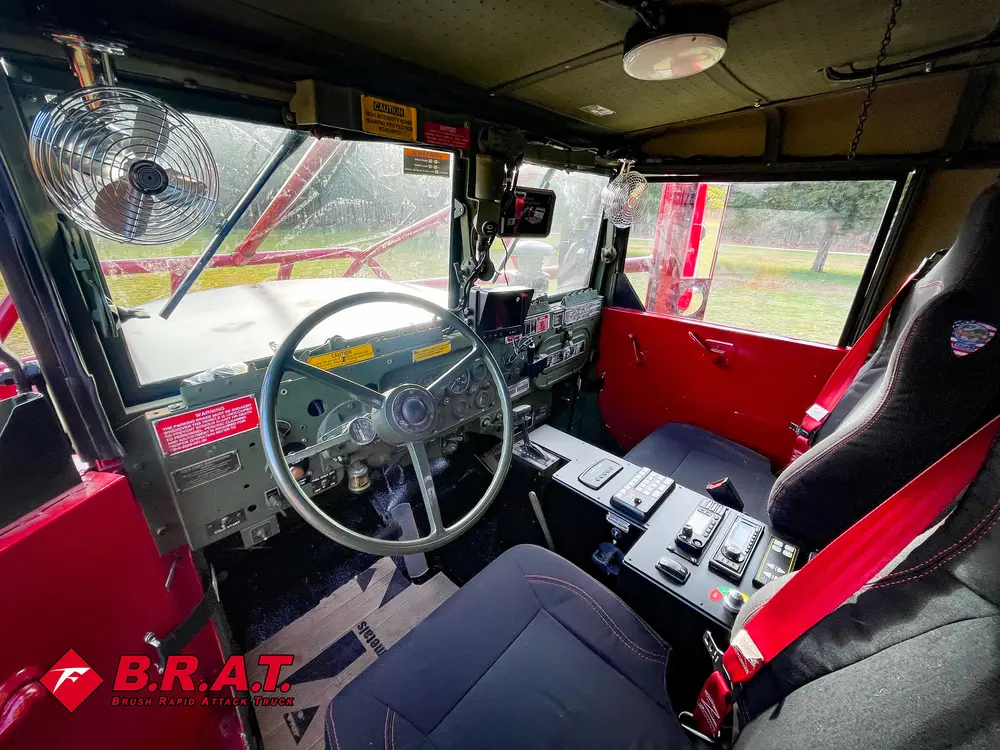 Exterior view of small fire truck showing cab, body compartments, and wheel/tire area.