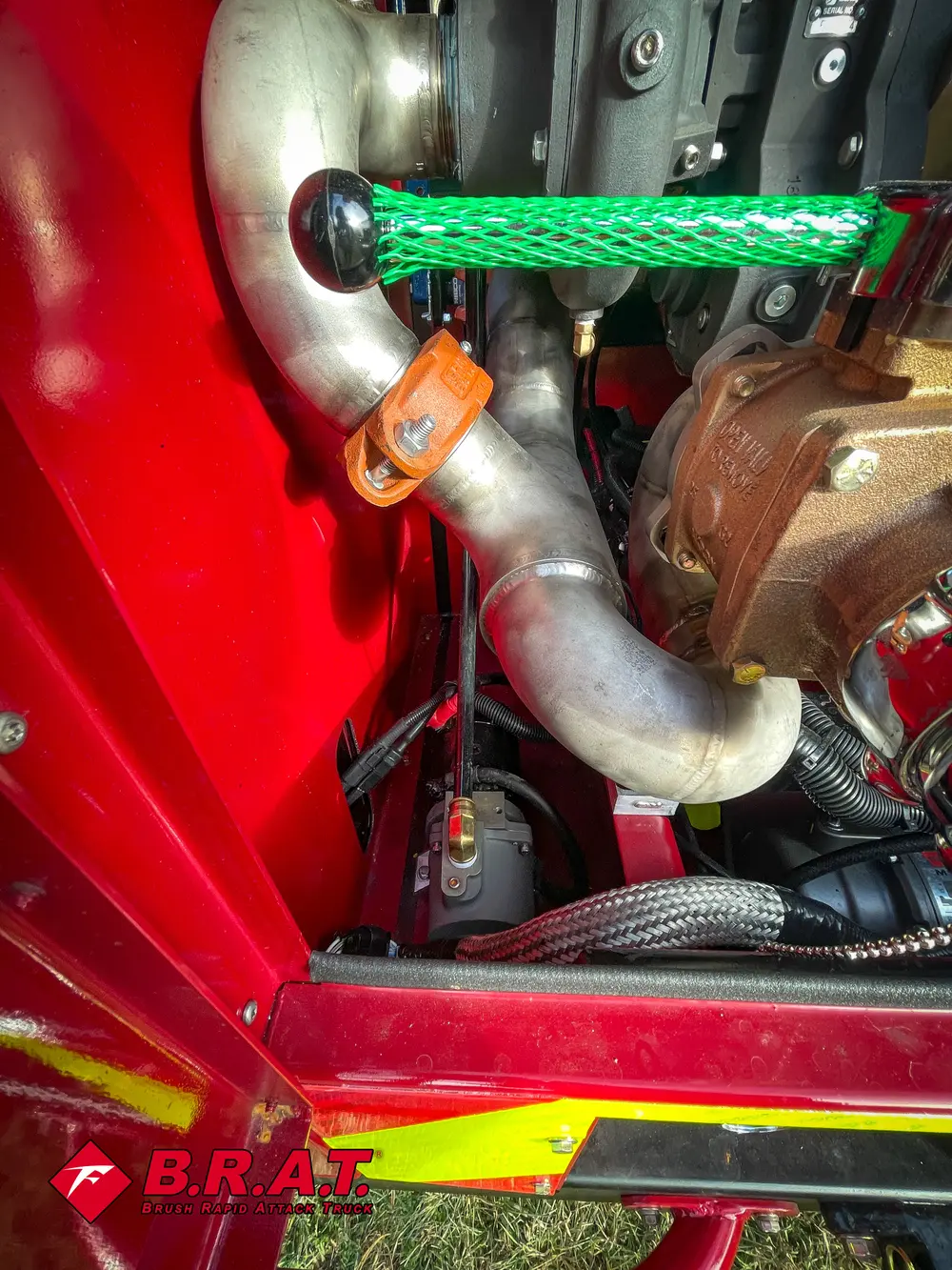 Exterior view of small fire truck showing cab, body compartments, and wheel/tire area.