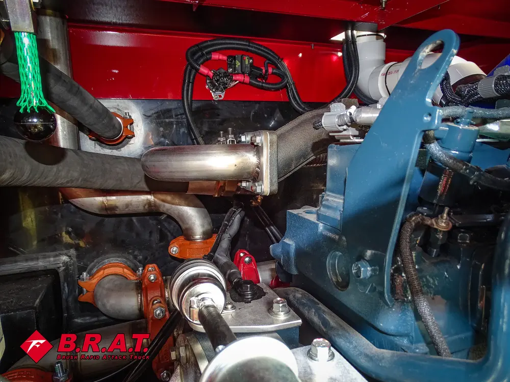 Exterior view of small fire truck showing cab, body compartments, and wheel/tire area.